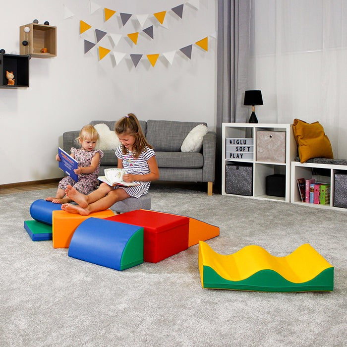 child gleefully building a colorful iglu foam block tower