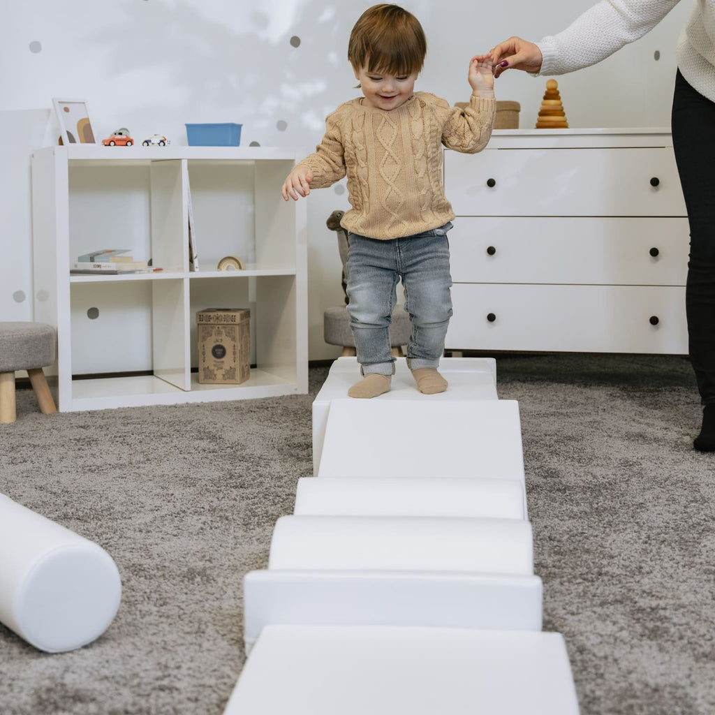 a soft white iglu foam block set arranged in a gentle, comforting nest-like formation for sensory play