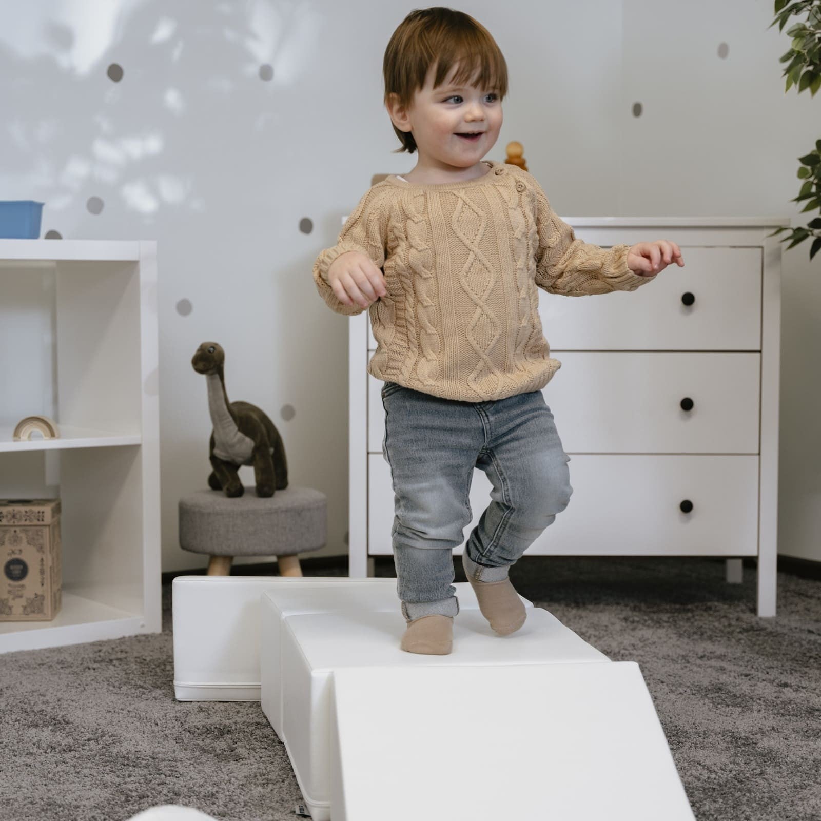 a child building a creative igloo fort with soft white foam blocks in a sunlit playroom