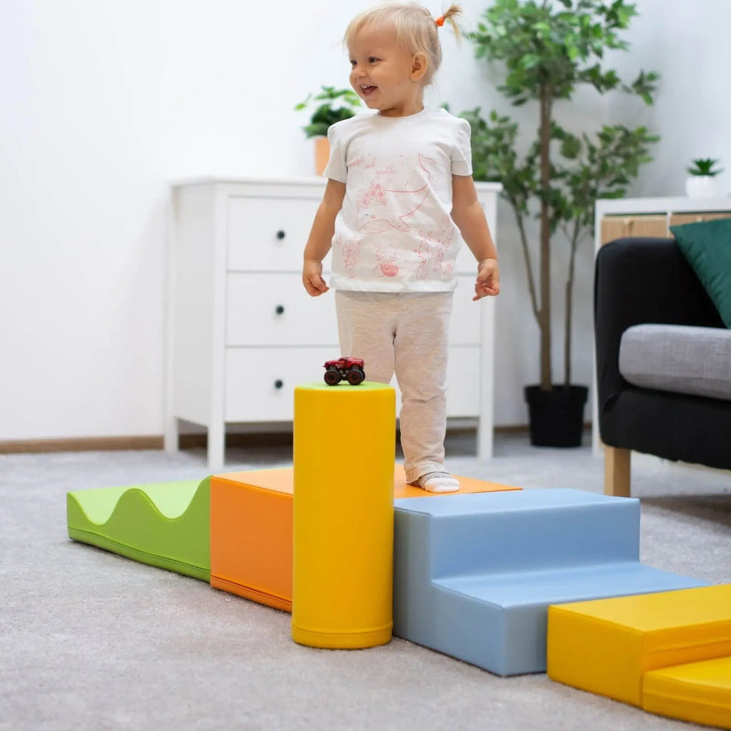 a toddler building a vibrant igloo from soft pastel foam blocks in a sunlit playroom