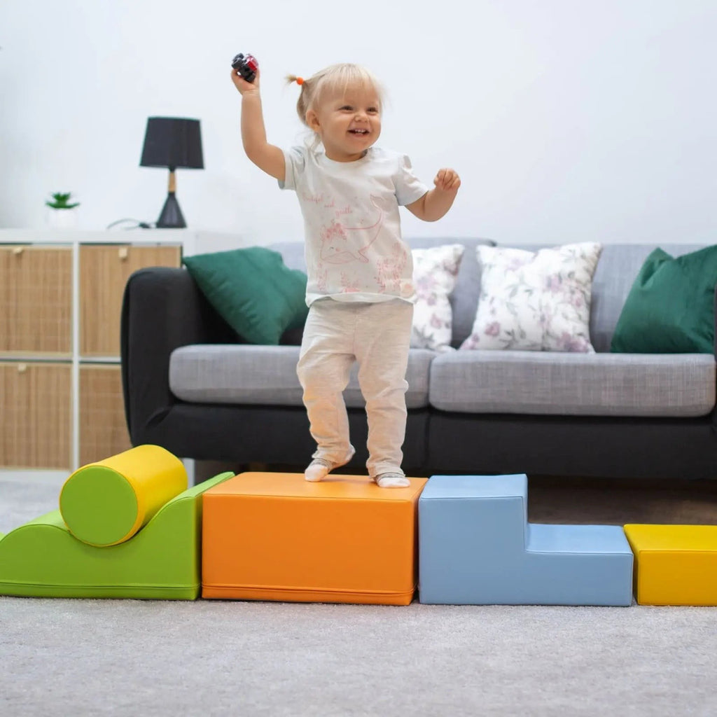 a toddler building a bright igloo fort from soft multicolor foam blocks