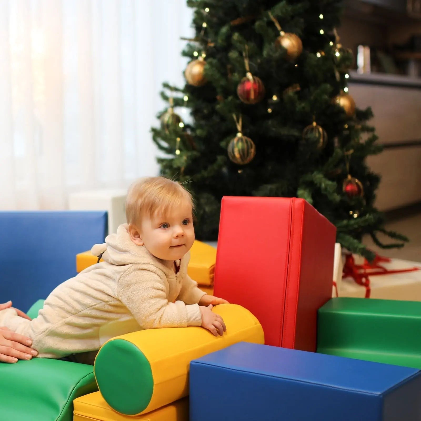 a child's hand reaching for a vibrant iglu soft foam block in a sunlit playroom