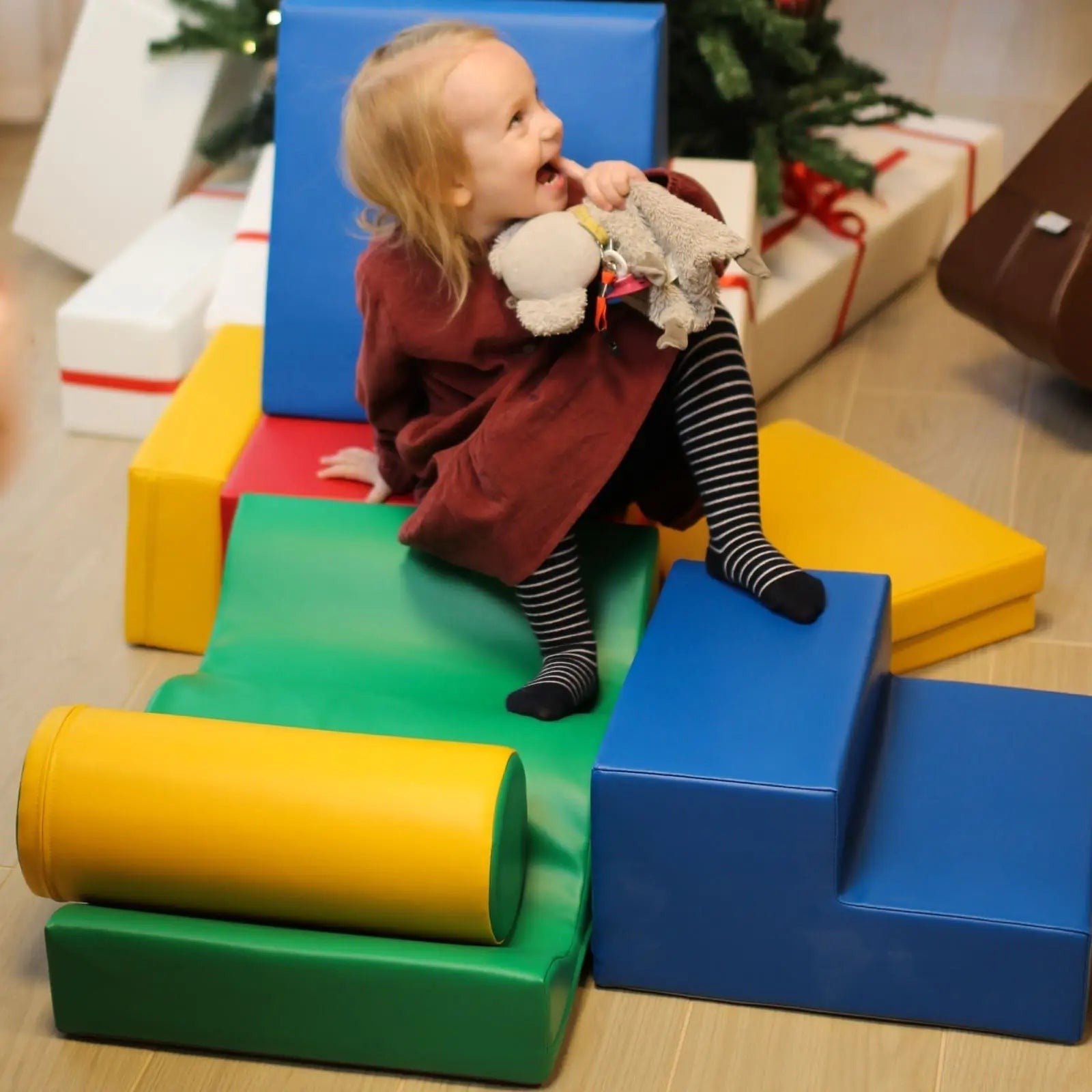a child's hand reaching for a stack of vibrant iglu foam blocks in soft morning light
