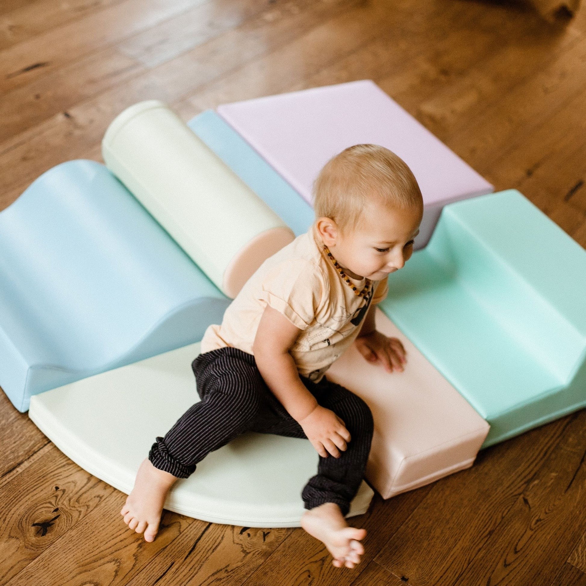 a toddler building a simple ramp structure with light pastel iglu foam blocks