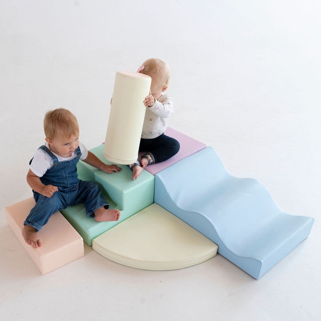 bold pastel iglu foam blocks arranged in a dynamic climbing arch for toddlers