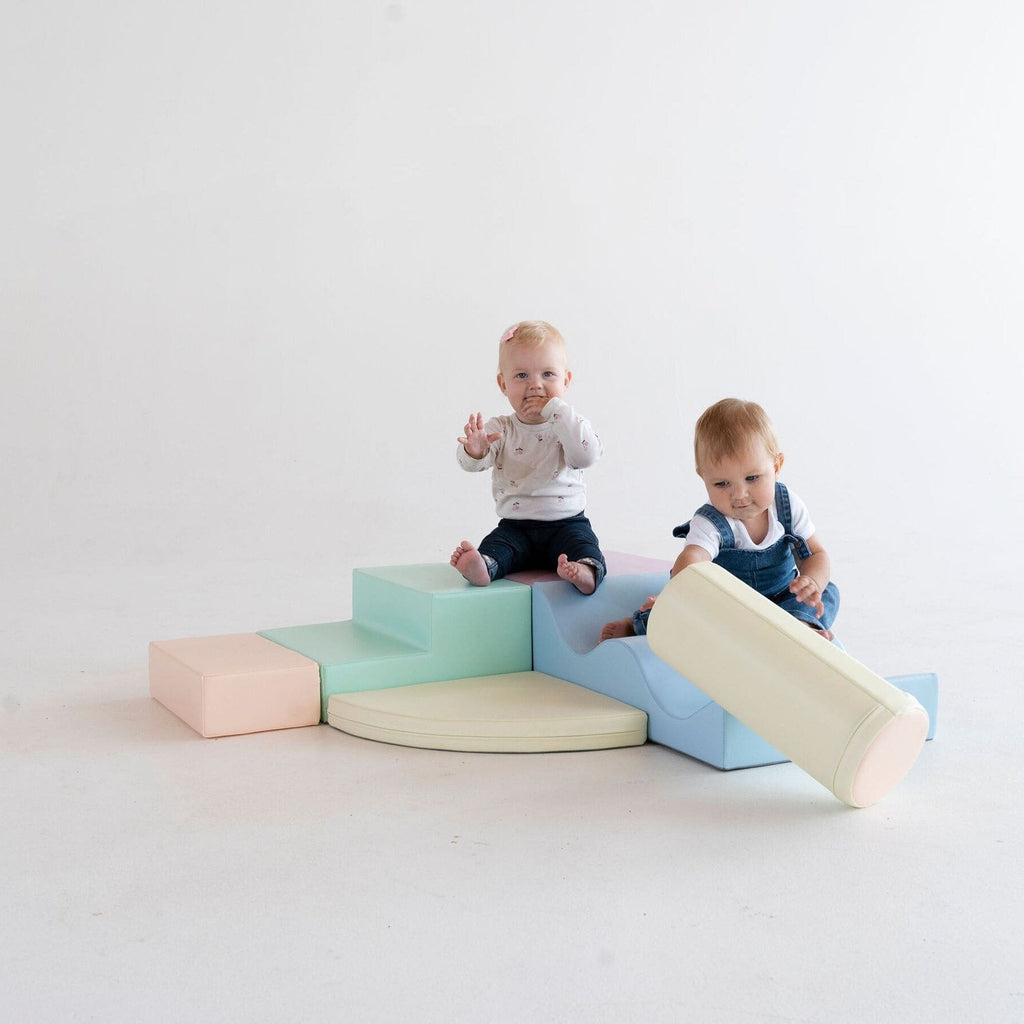 toddler building a soft pastel igloo with light pastel foam blocks