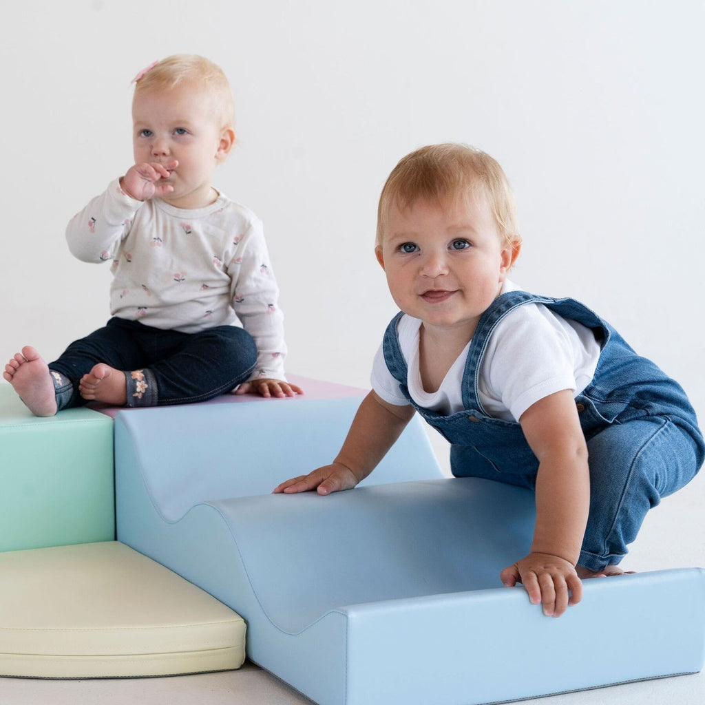toddler building a pastel foam block fort in soft morning light
