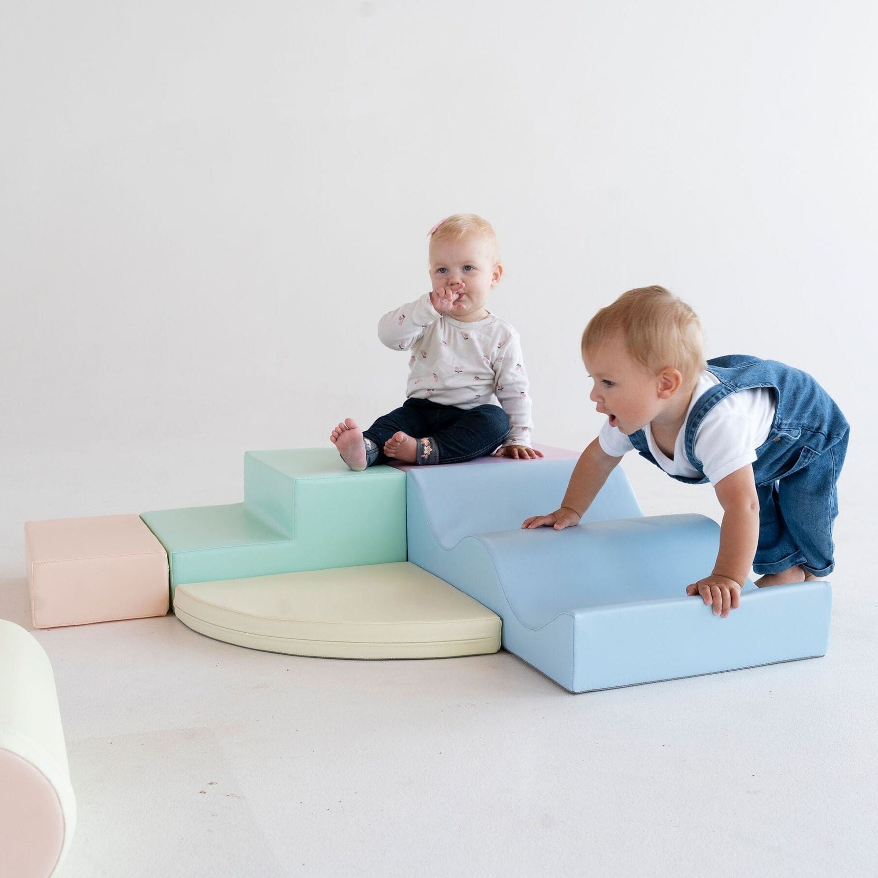 a toddler building a soft pastel foam block fort in a sunlit playroom