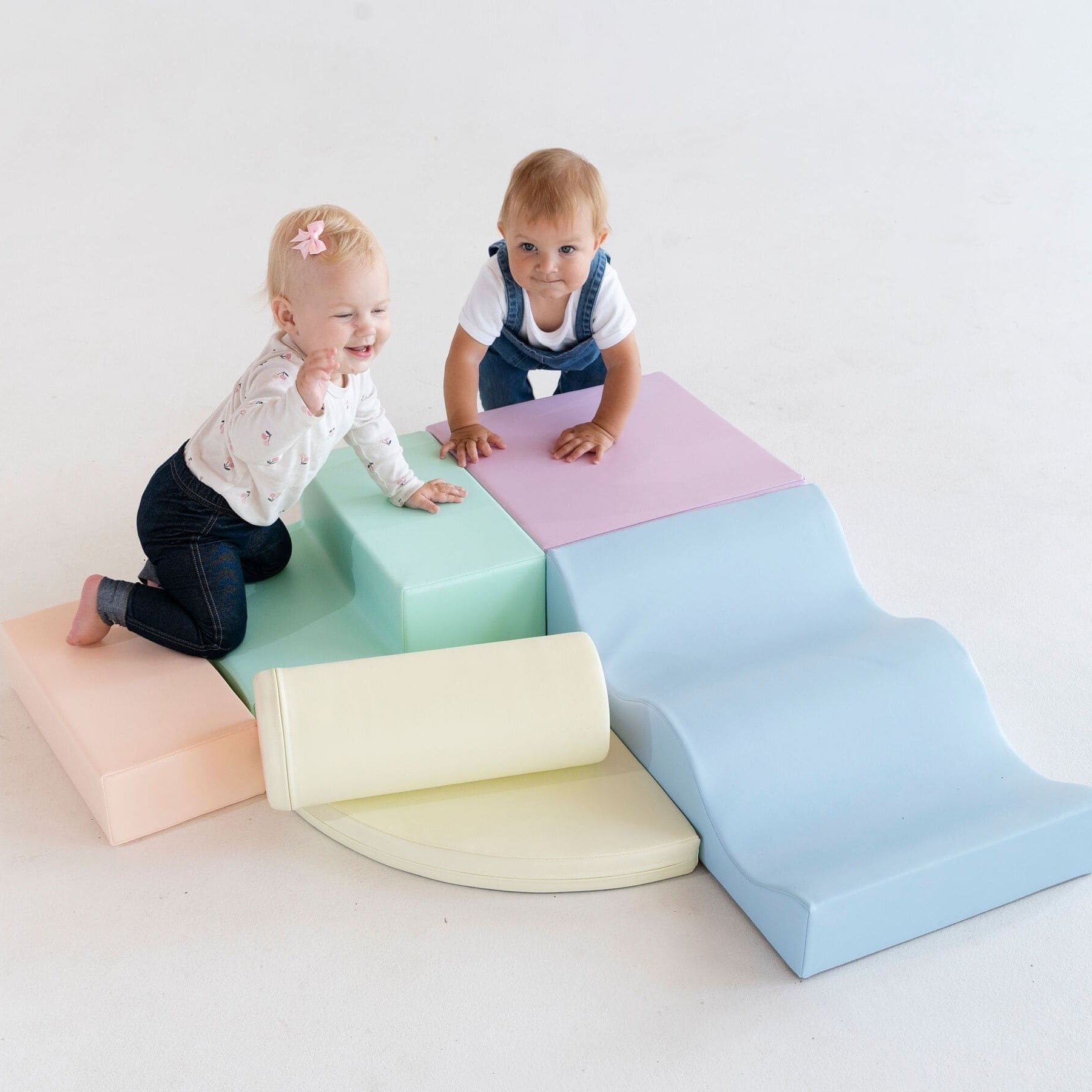 a toddler building a cozy pastel igloo fort with soft foam blocks