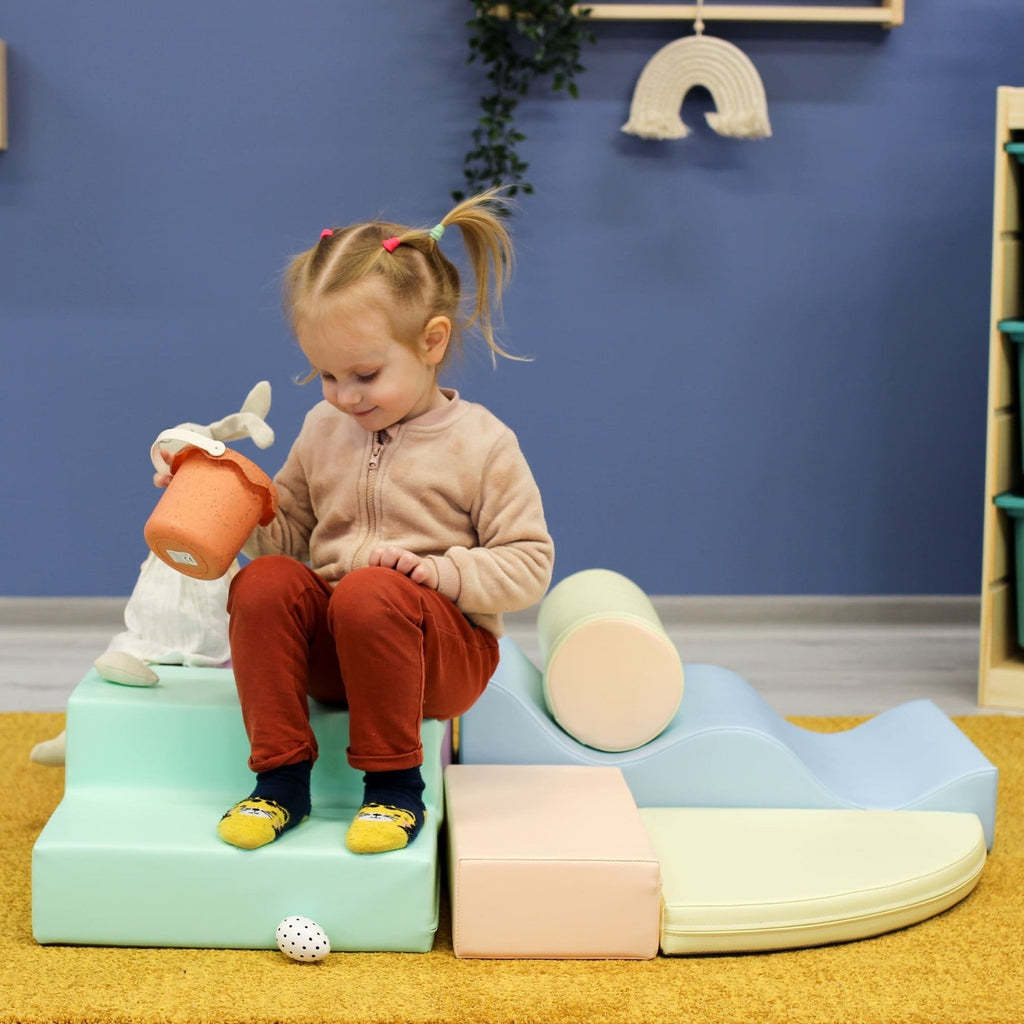 a toddler building a cozy pastel igloo fort with soft foam blocks