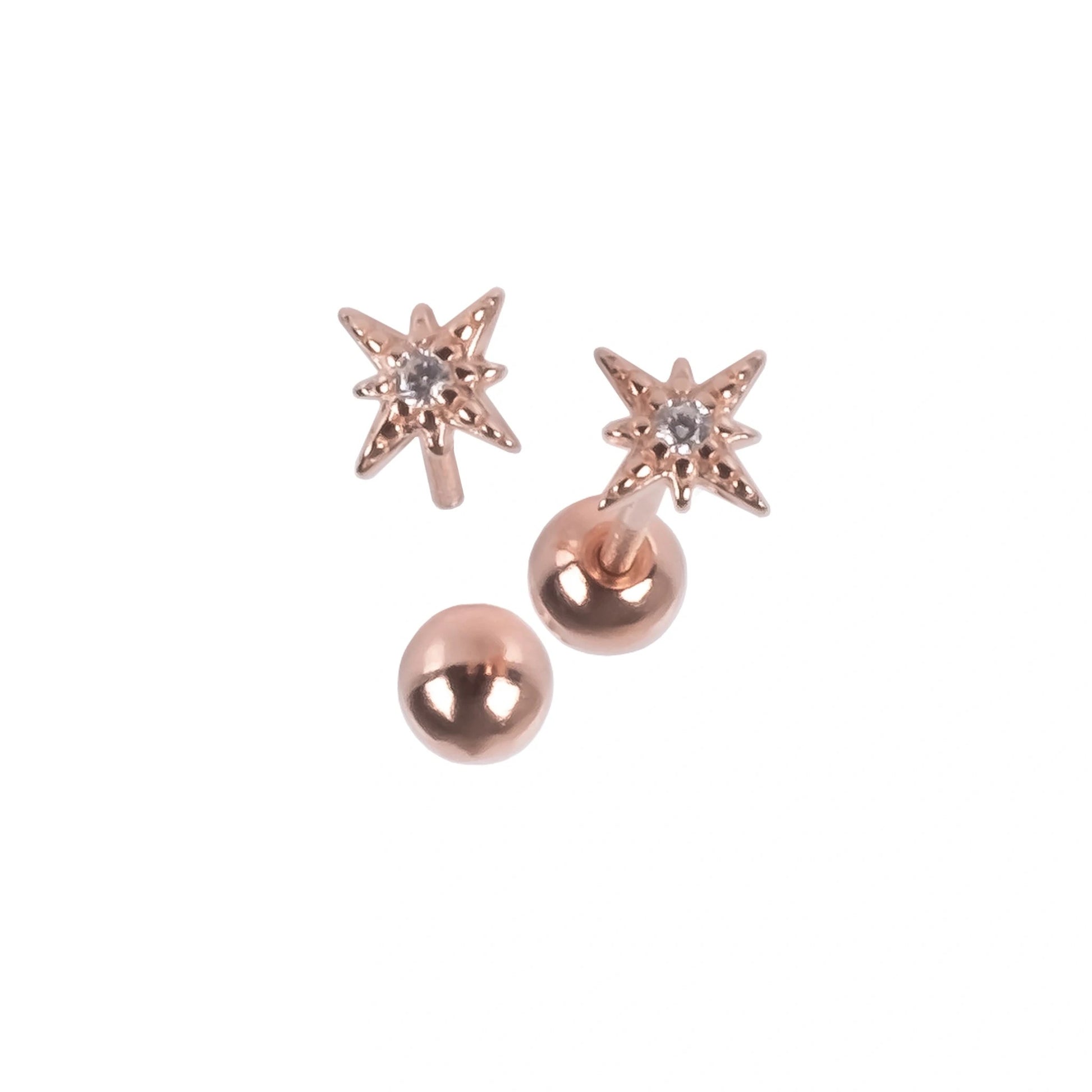 a playful close-up of tiny silver star earrings twinkling against a soft, colorful baby blanket