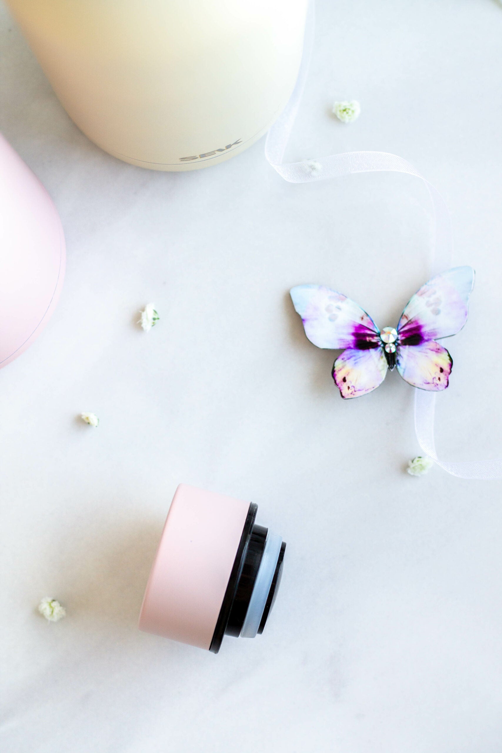 a playful pink seik thermos held by a hand, splashing water in the background