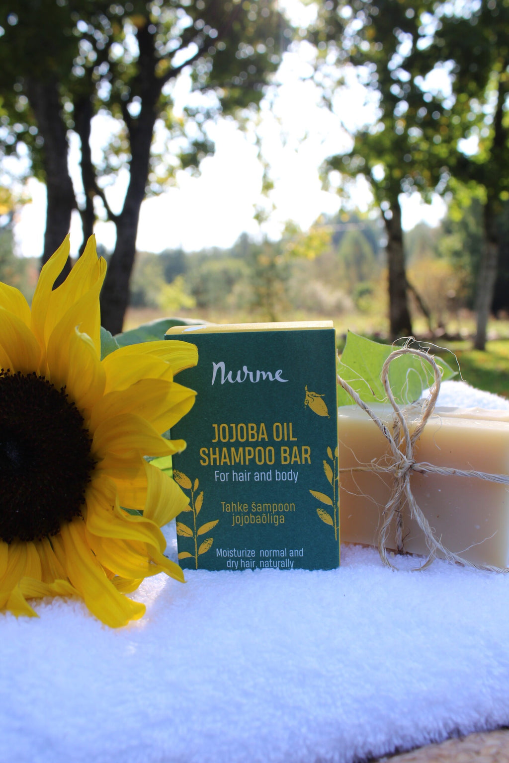 a soft-focus close-up of a nourishing jojoba oil shampoo bar resting on natural wood