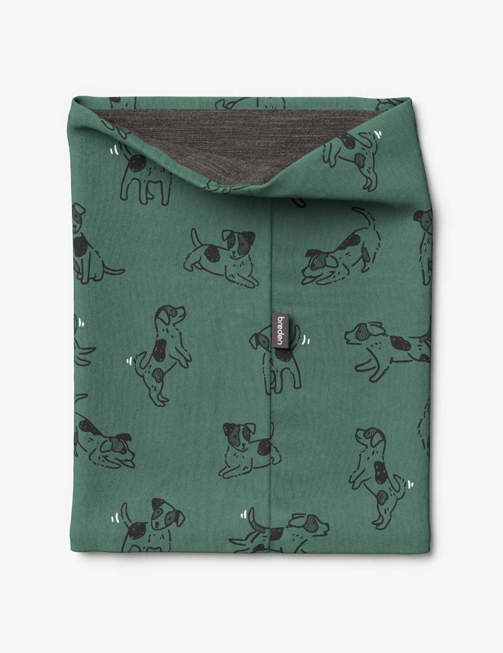 bold green kids merino neck tube with a playful dog print, shown in dramatic morning light