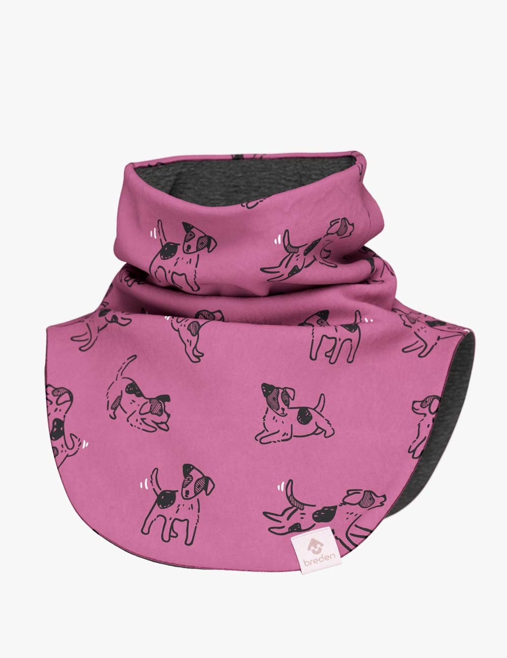 a soft pink kids merino neck warmer with playful dog patterns, shown in gentle morning light