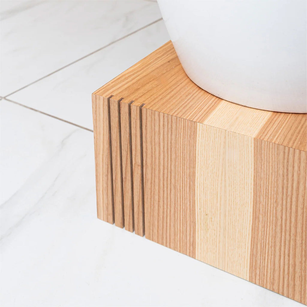 a playful stack of three birch plywood cube plant stands in a sunlit room