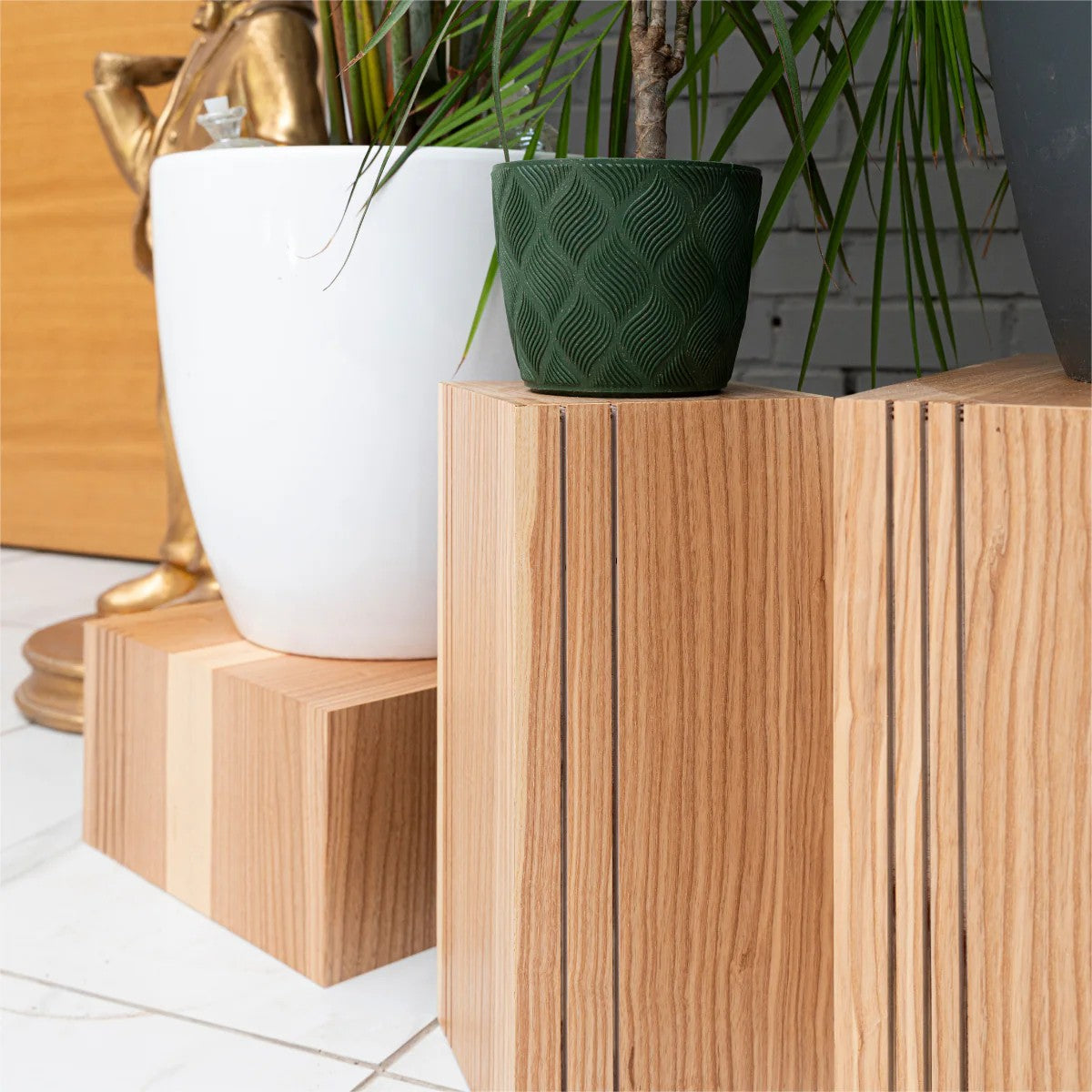 elegant set of three latvian-crafted wooden cube plant stands in a refined minimalist interior