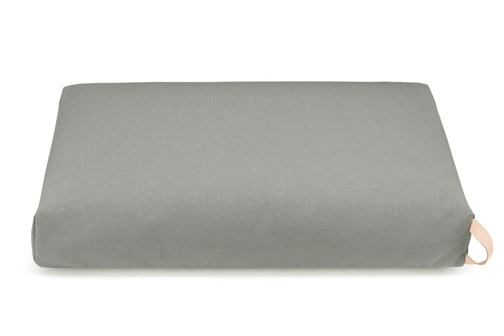 dark grey kiima dog cushion with natural leather handle in soft morning light