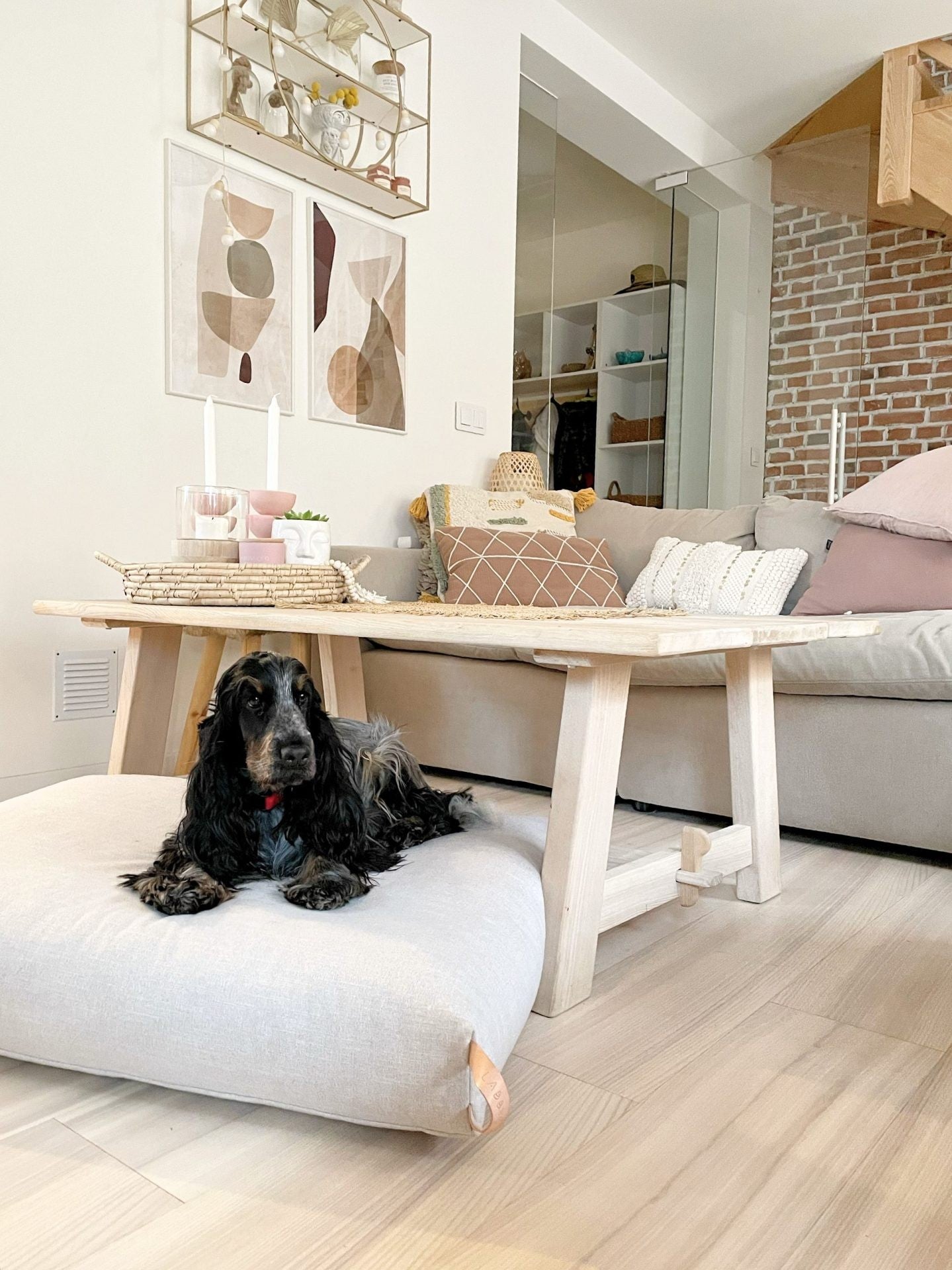 bold kiima dog cushion in light beige with natural leather handle on a dark slate floor