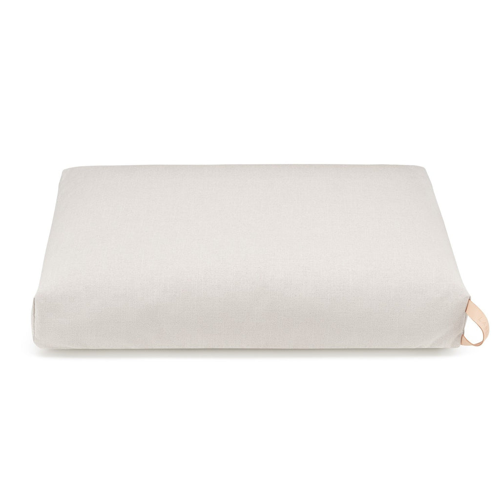 soft beige kiima dog cushion with a natural leather handle in cozy morning light