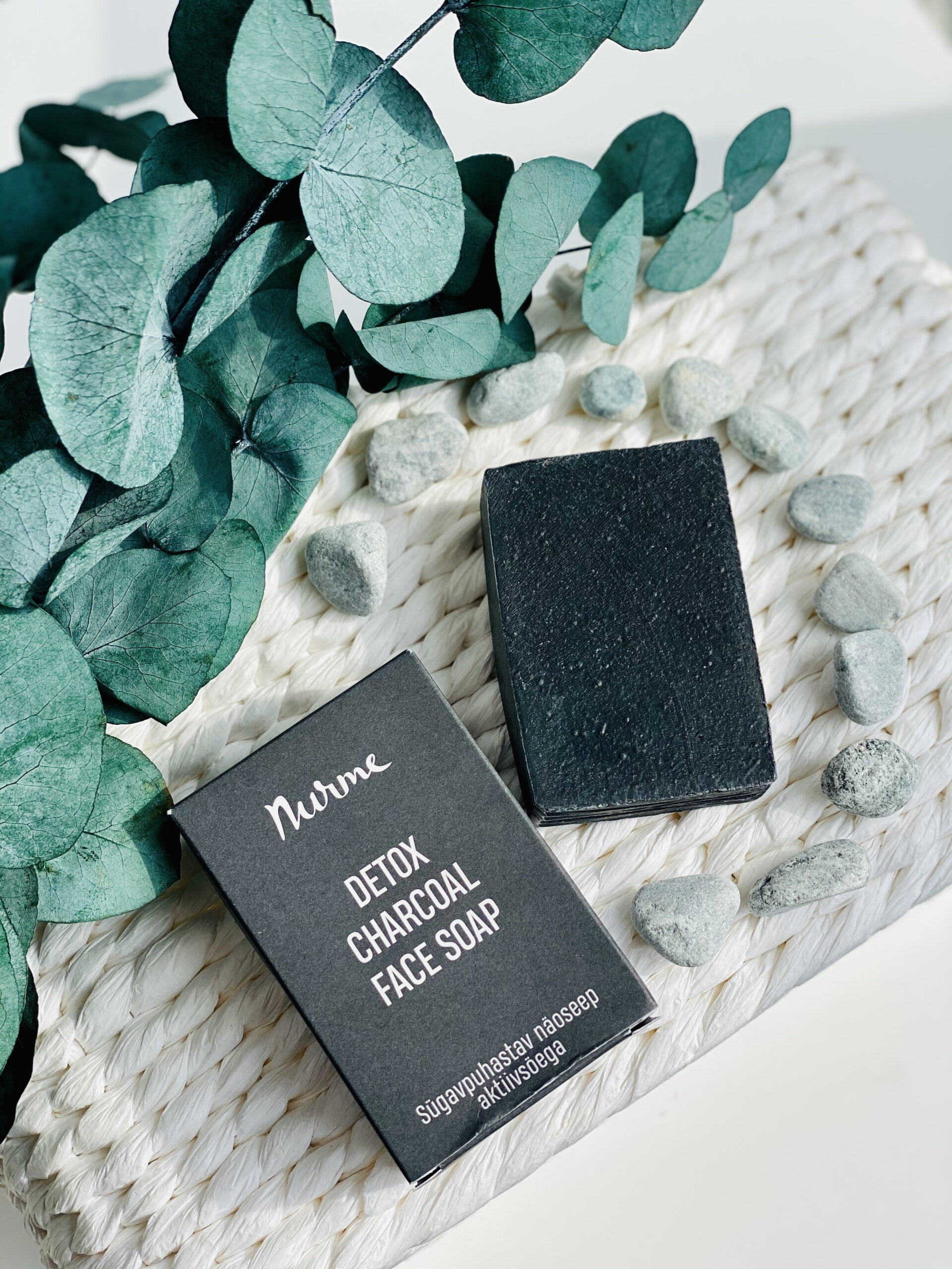 bold black charcoal and goat milk facial cleansing bar on a dark slate background