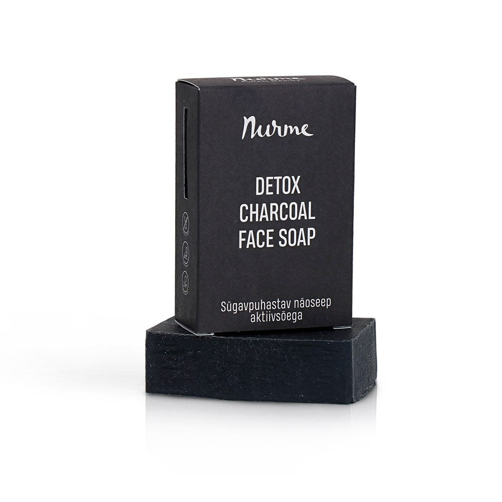 elegant black charcoal and goat milk facial cleansing bar on a minimalist marble surface