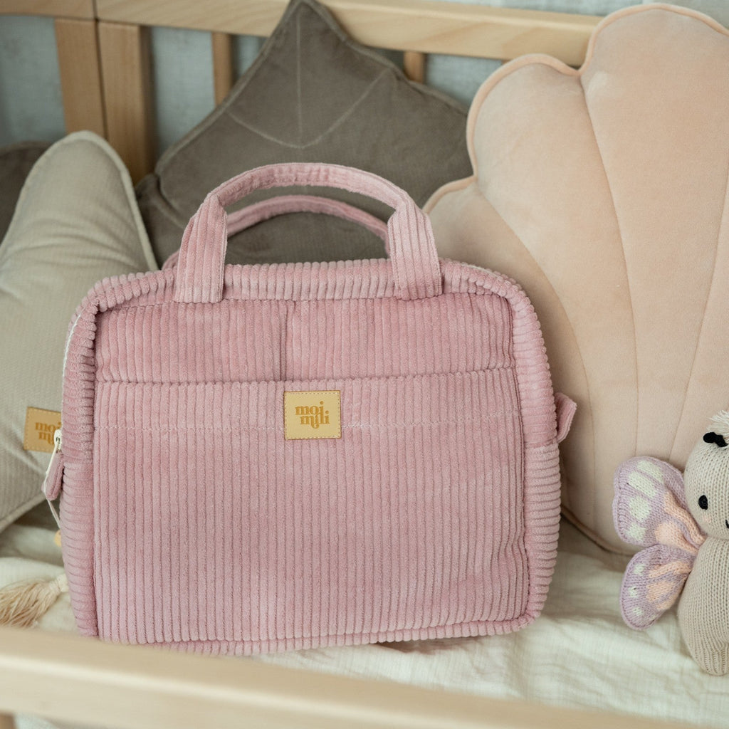 bold baby pink cotton makeup bag with waterproof lining and pockets open on a dark surface