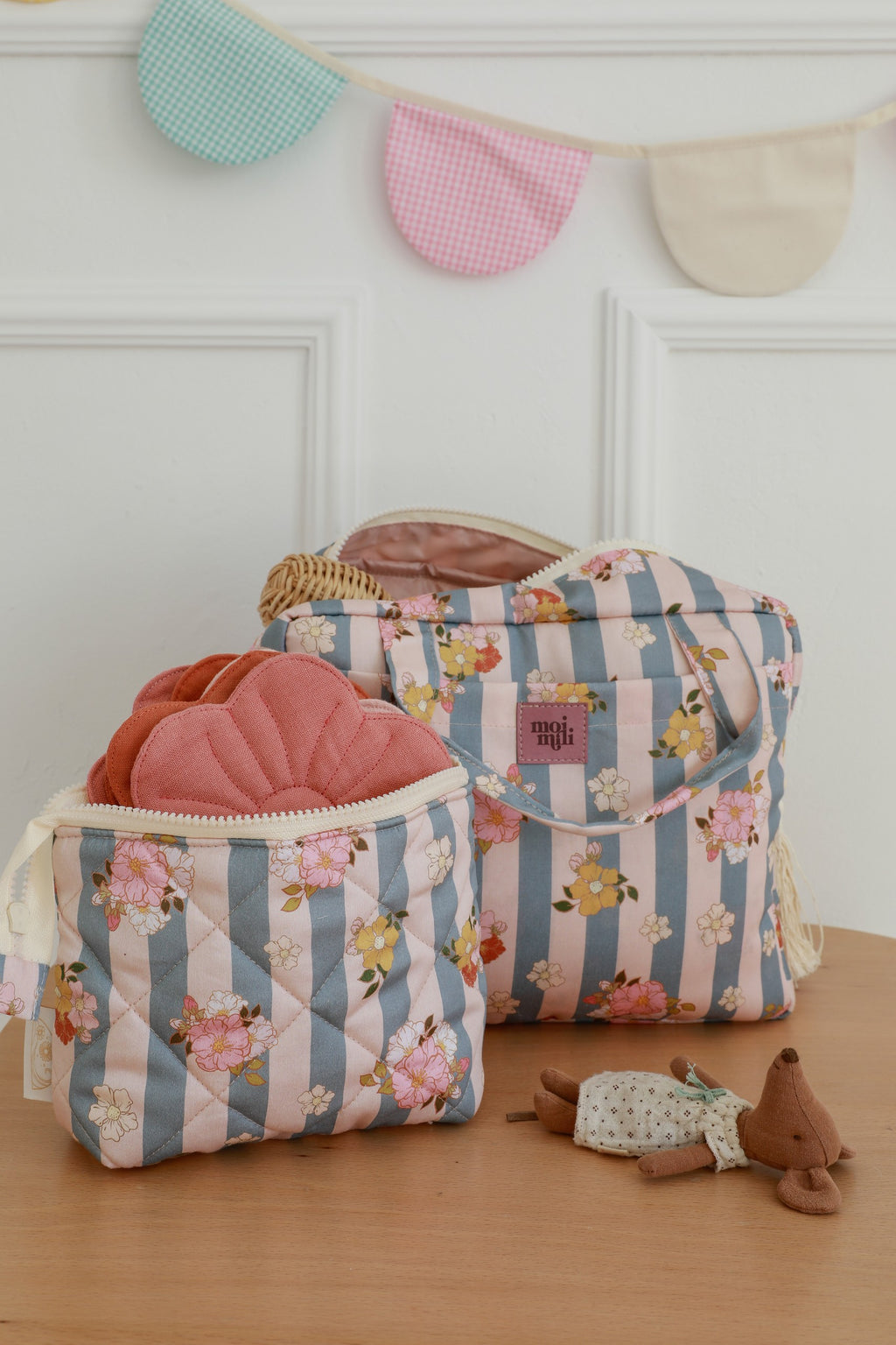 bold blue striped makeup bag set open on a table showcasing its spacious waterproof interior