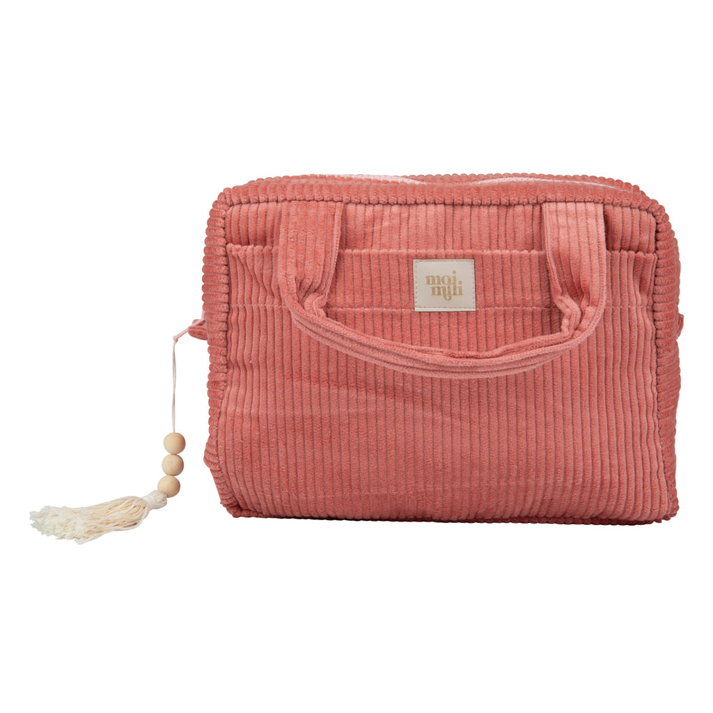 handmade coral cotton makeup bag open on a sandy beach, showing its spacious interior and pockets