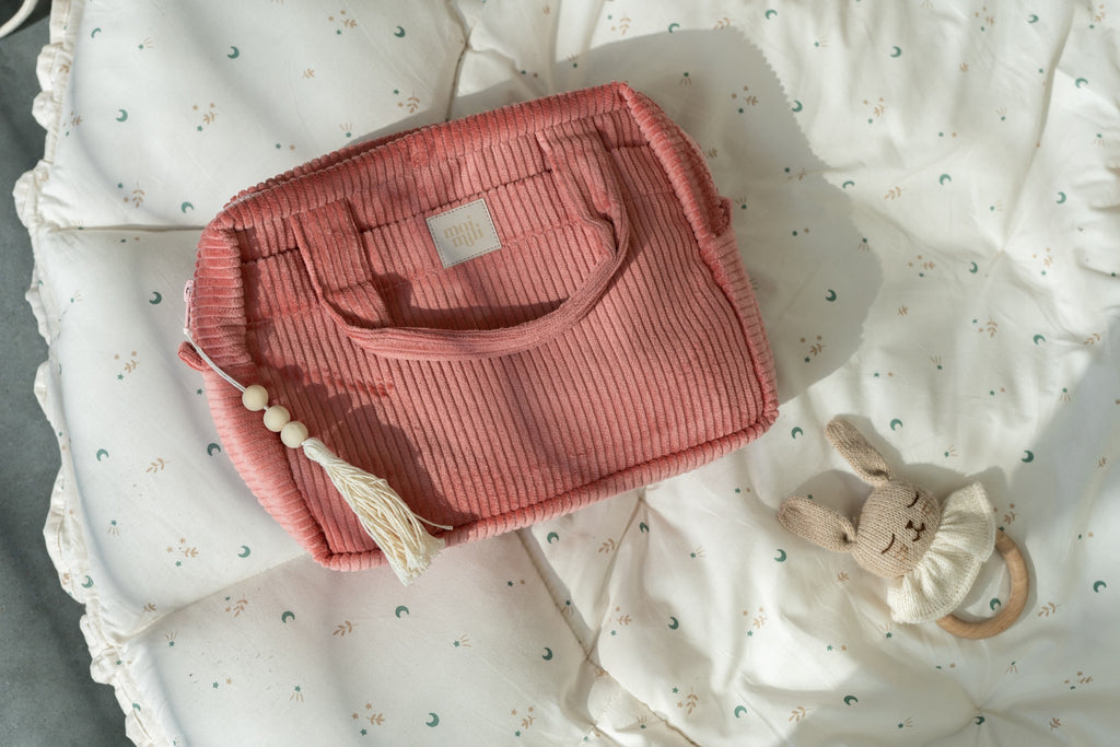elegant coral cotton makeup bag open on a marble surface revealing its inner pocket