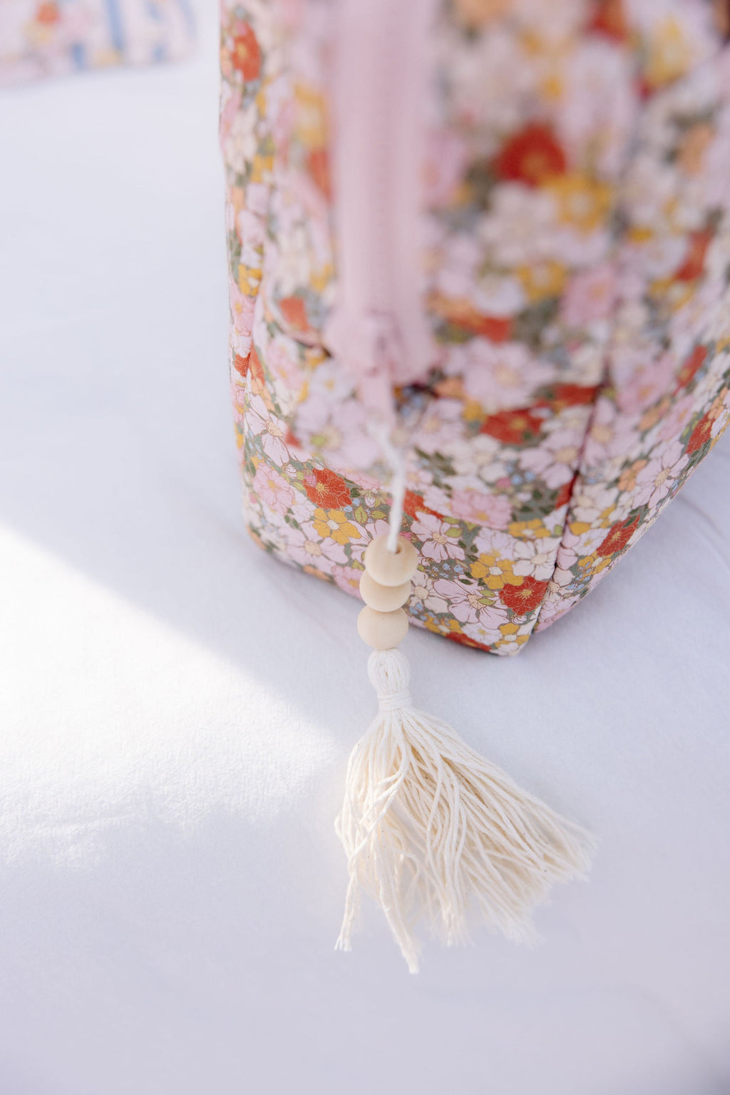 green garden makeup bag with waterproof lining and pockets, laid on a rustic wooden table with soft sunlight
