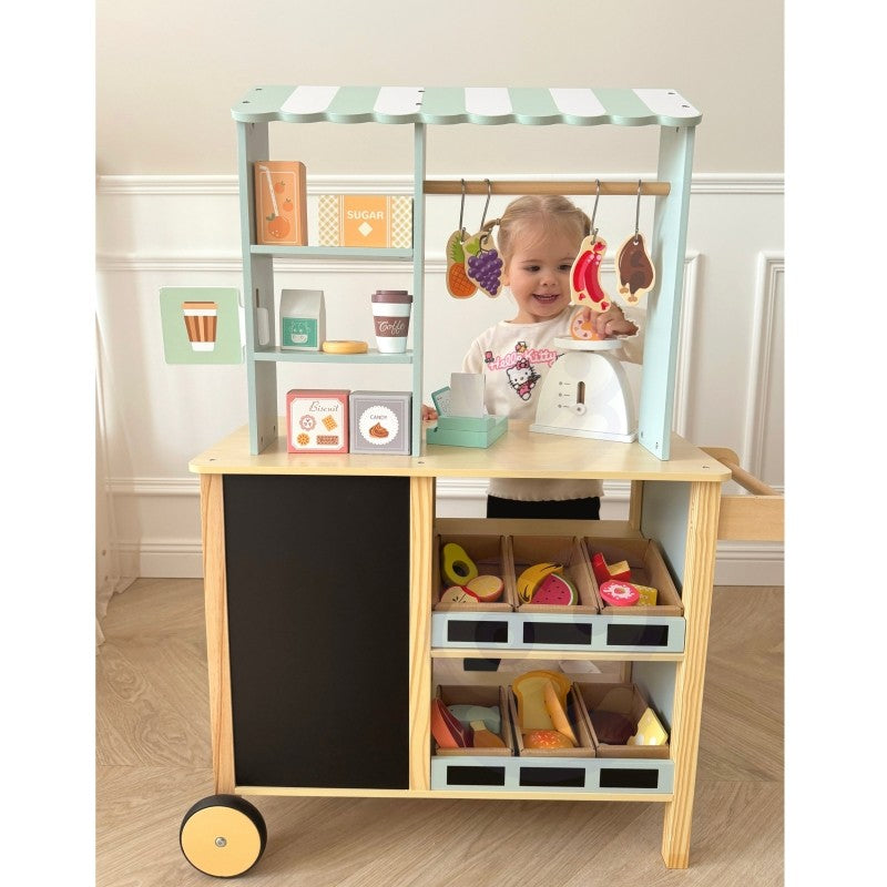 a child's hands using the wooden card reader and scale on the woopie green food truck stand