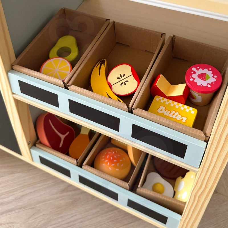 child's hand using the wooden card reader at the vibrant green food truck stand