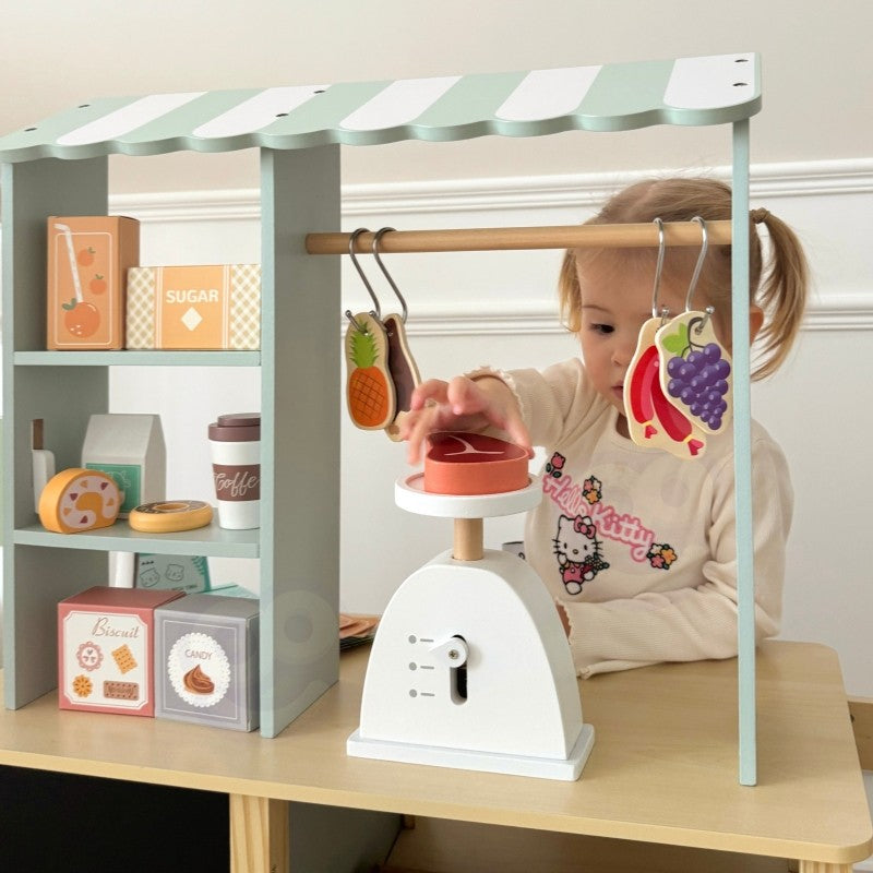 a child's hands using the wooden card reader at the woopie green food truck stand