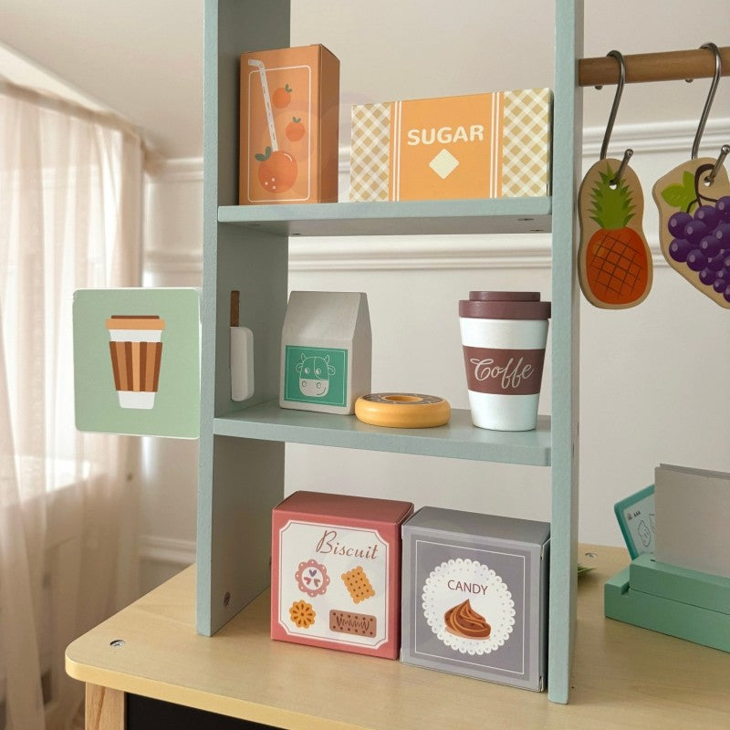 a child's hands organizing vibrant play food on the woopie green wooden food truck counter