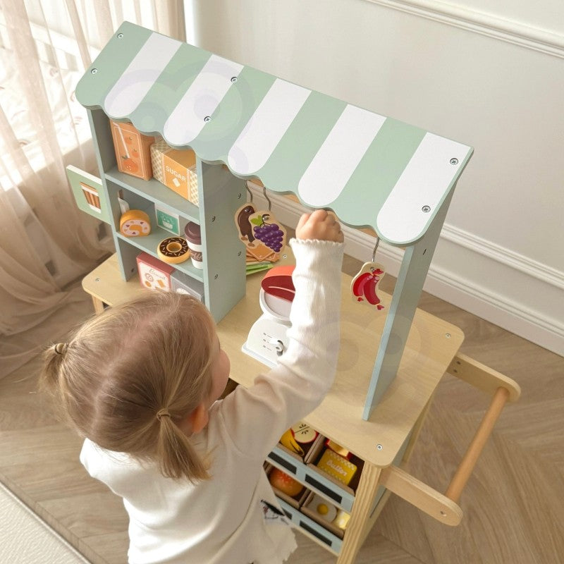a child's hand using the wooden card reader at the woopie green food truck stand