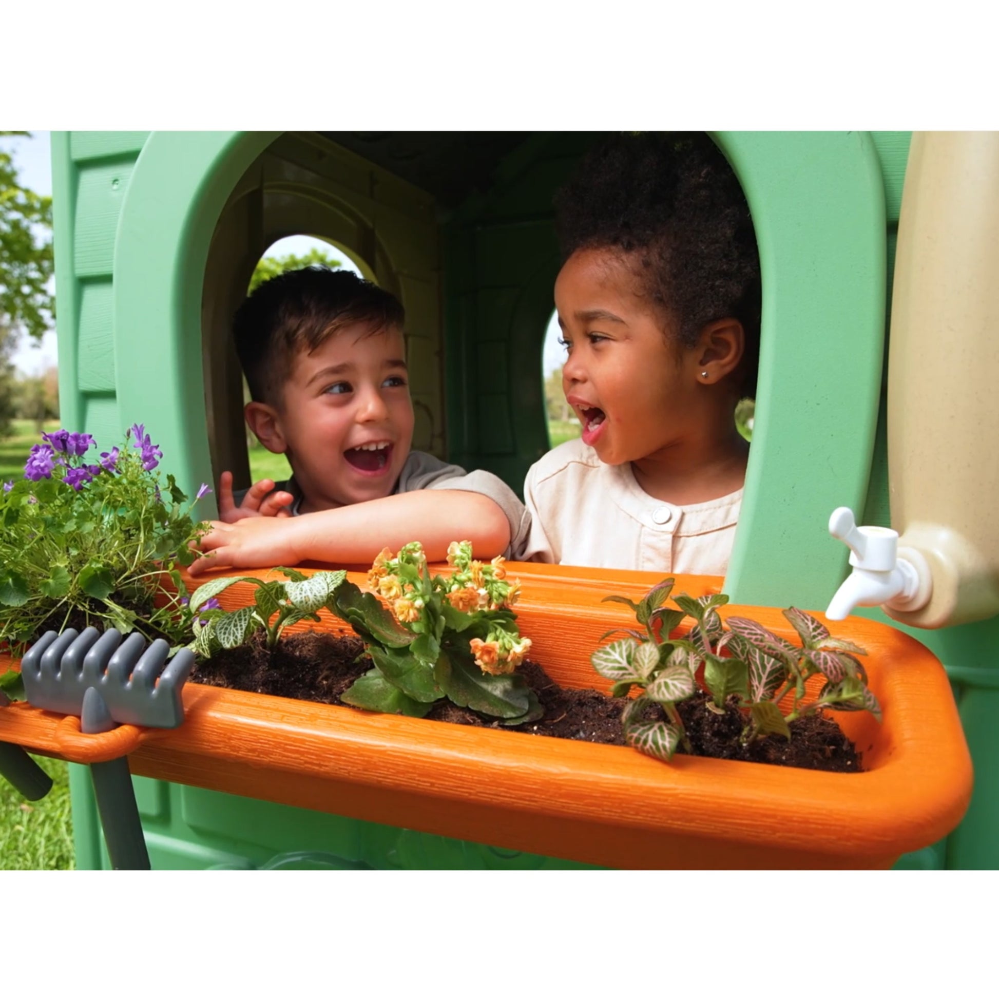 kids laughing while planting in the feber eco playhouse with solar panels and wind turbine