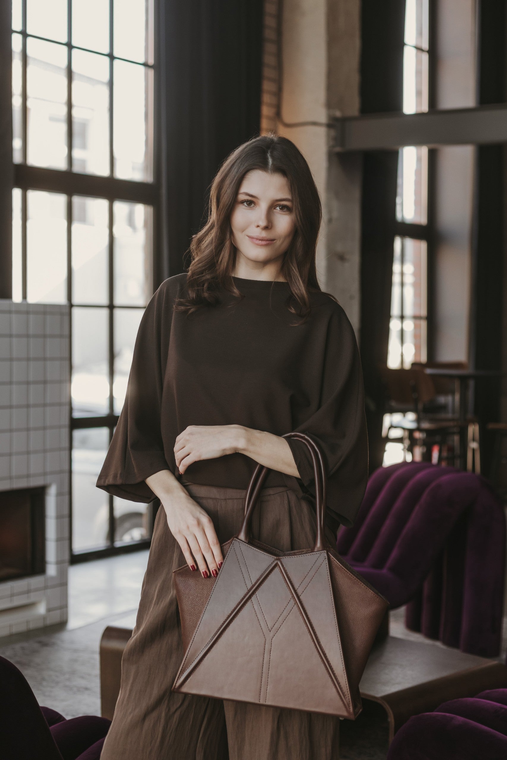 softly lit gerda retter leather tote bag open on a cozy table showing its inner pocket