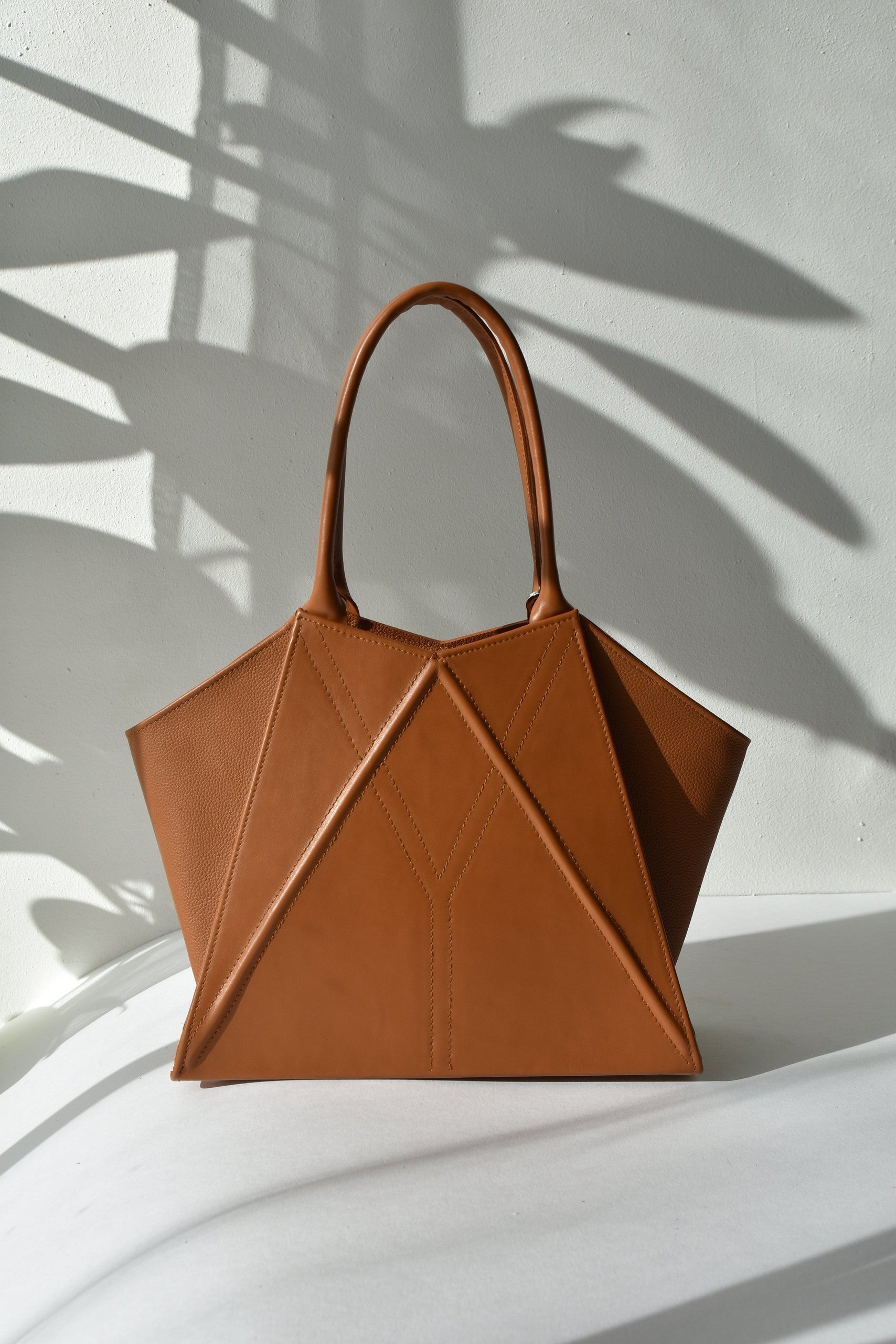 elegant gerda retter leather tote bag with magnetic closure in warm studio lighting