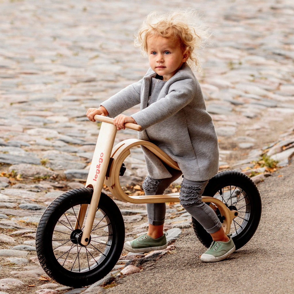 elegant birch balance bike in a refined home setting, showcasing its smooth curves and minimalist design