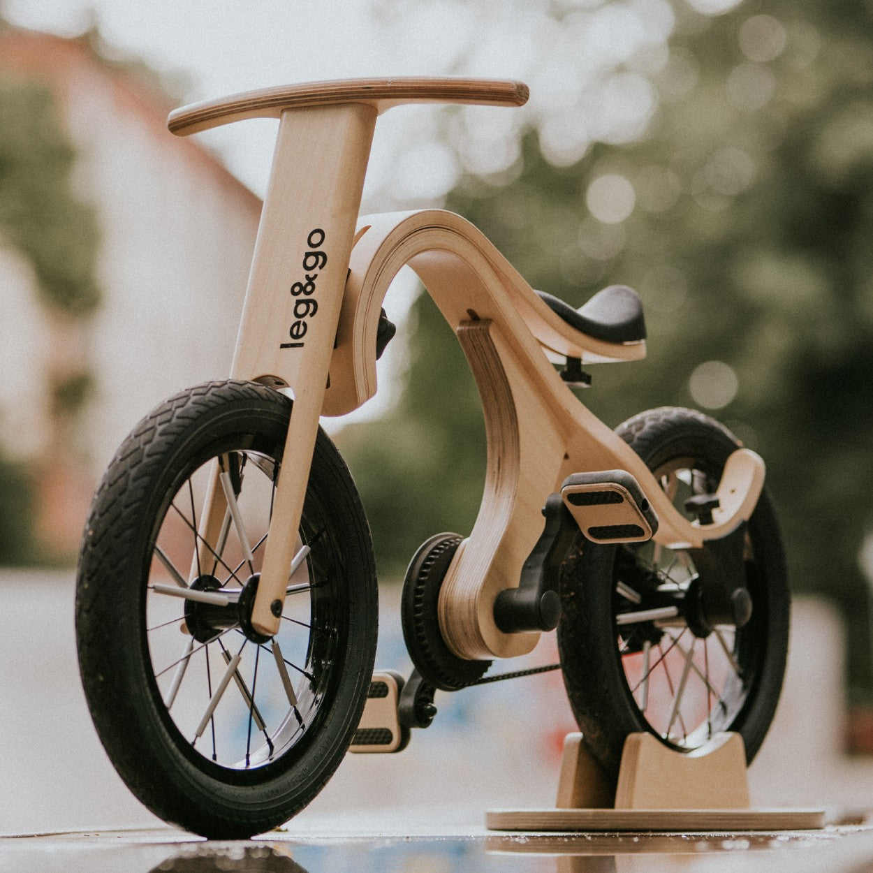 a child's hand on the wooden pedal of a lightweight balance bike conversion kit