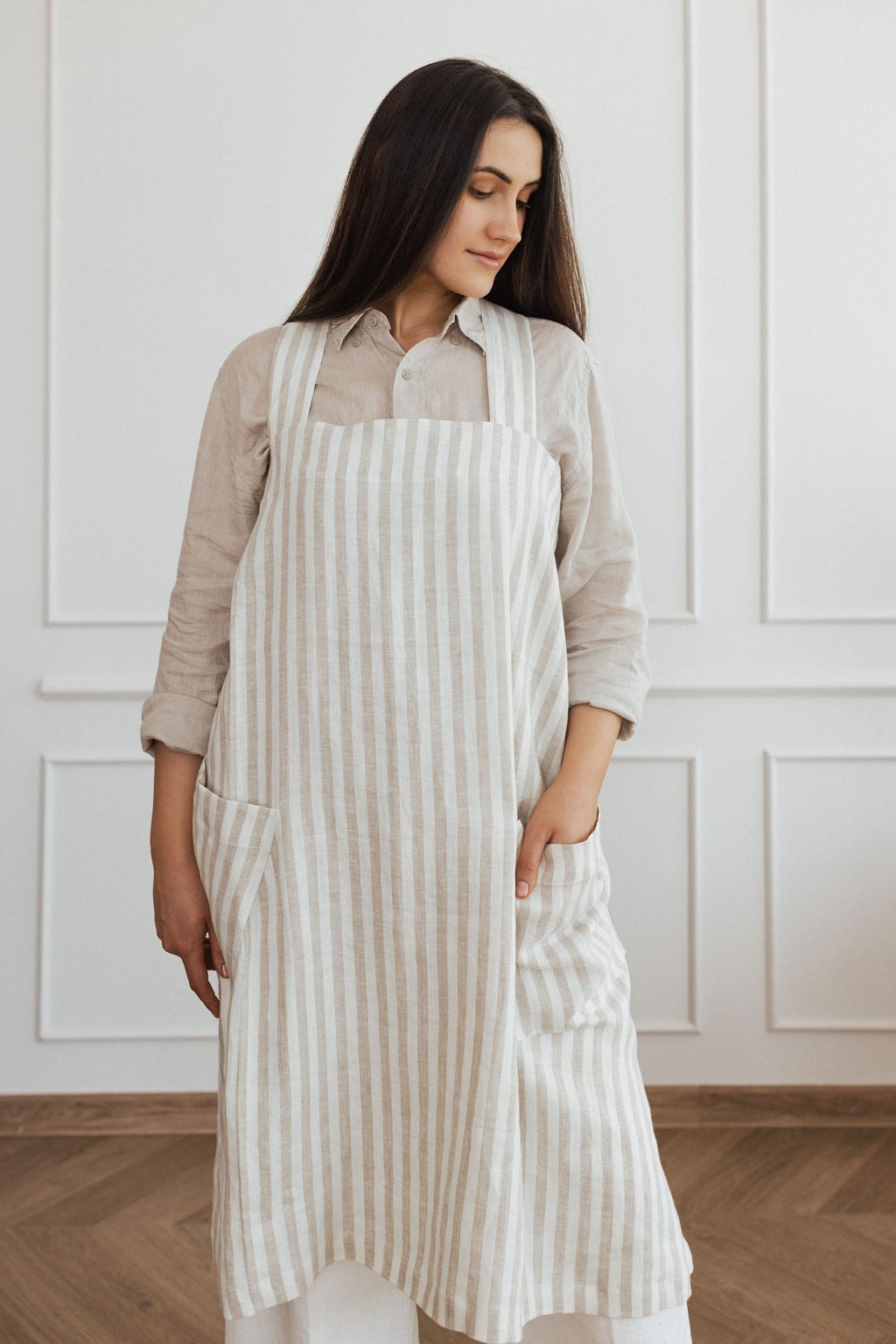 bold confident woman in a stylish linen apron with crossed back straps and deep pockets