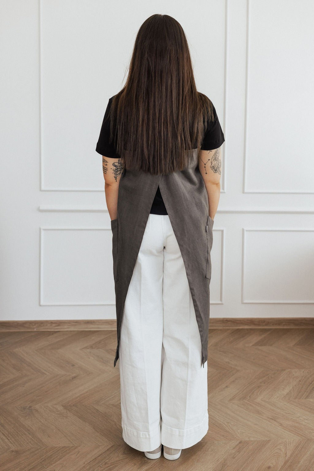 elegant linen apron with crossed back straps and two pockets, shown in a warm, natural light