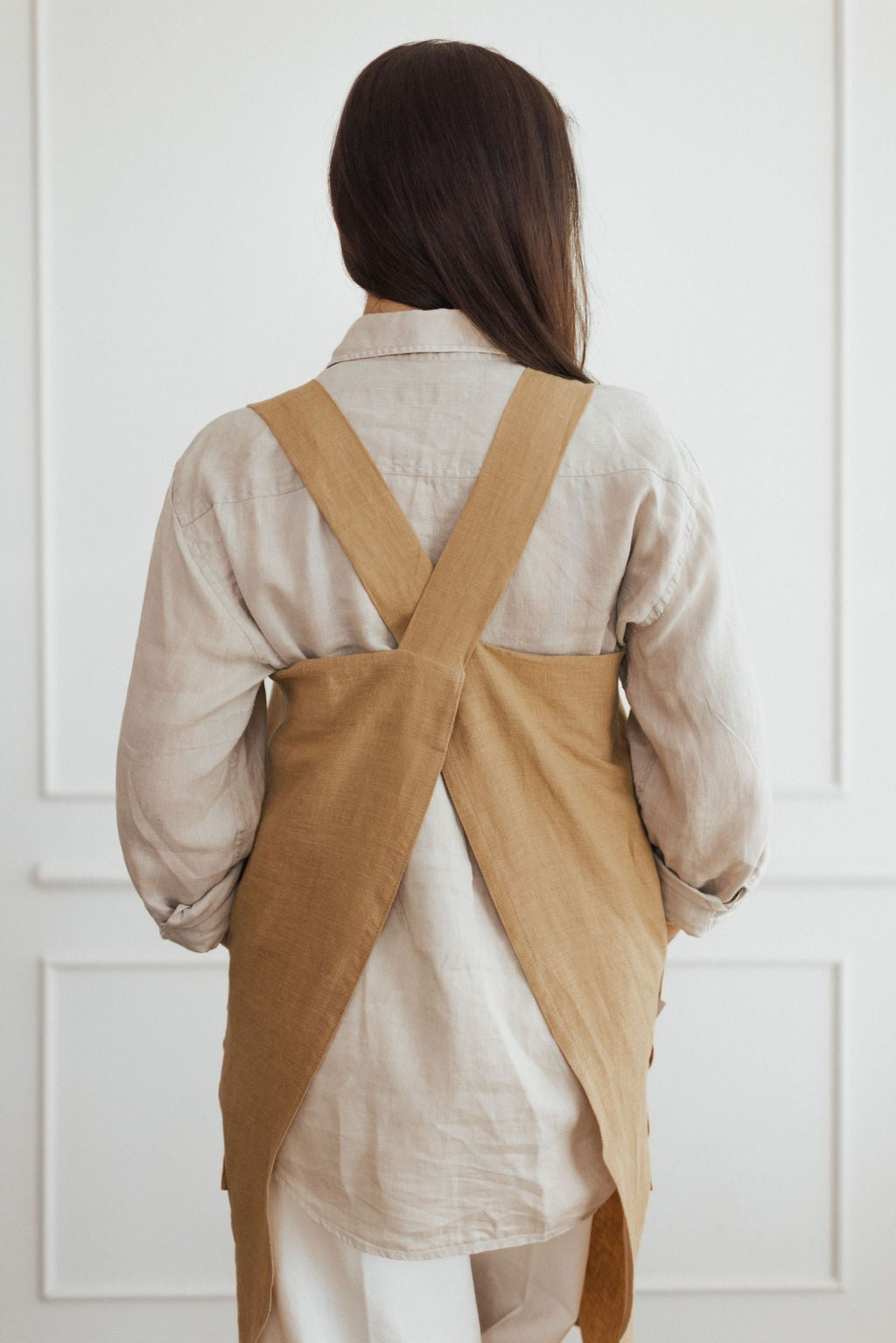 handmade linen apron with adjustable straps and side pockets, shown in warm afternoon light
