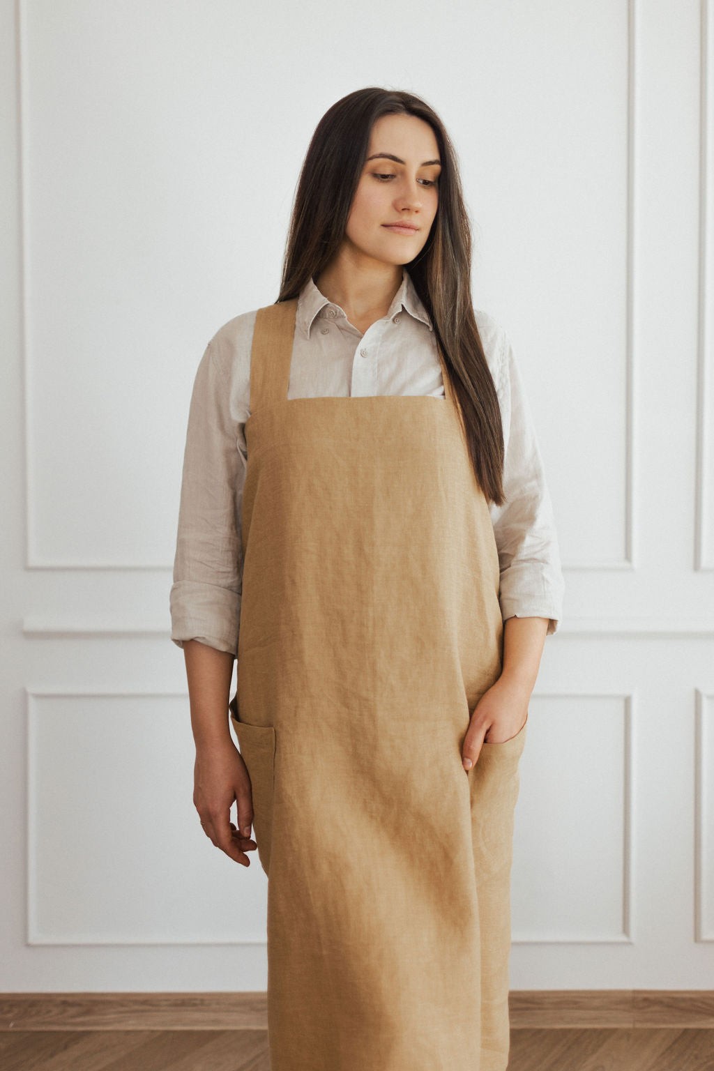 elegant linen apron with crossed back straps in a refined, sophisticated studio setting