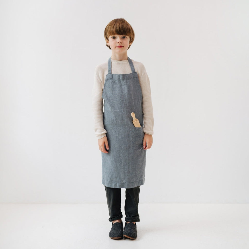bold close-up of a handmade kids linen apron with a deep front pocket and adjustable ties