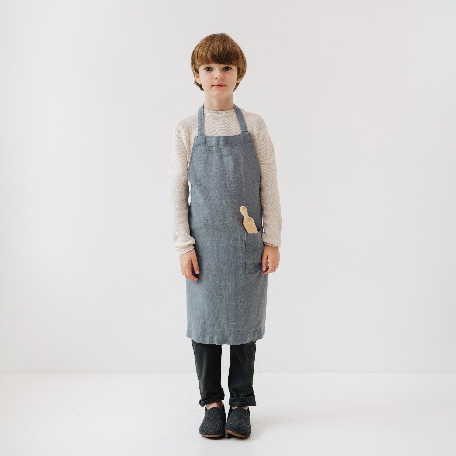 bold close-up of a handmade kids linen apron with a deep front pocket and adjustable ties