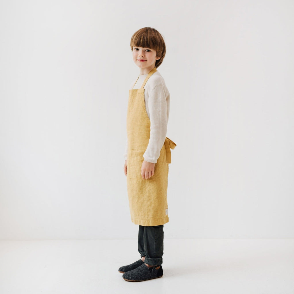 confident young baker in a honey linen apron with a front pocket for tools