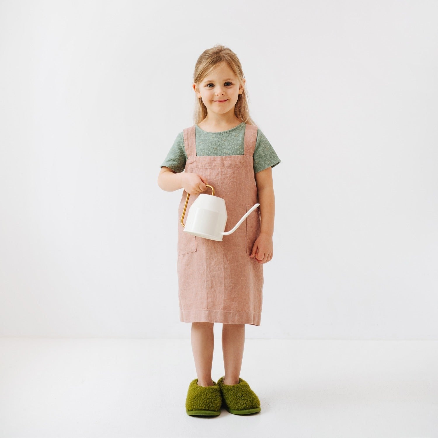 elegant honey linen kids apron on wooden table, showcasing its refined texture and practical pockets