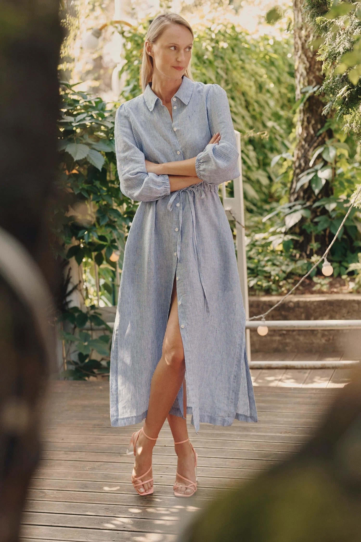 confident woman in a bold blue and white striped linen dress with a cinched waist